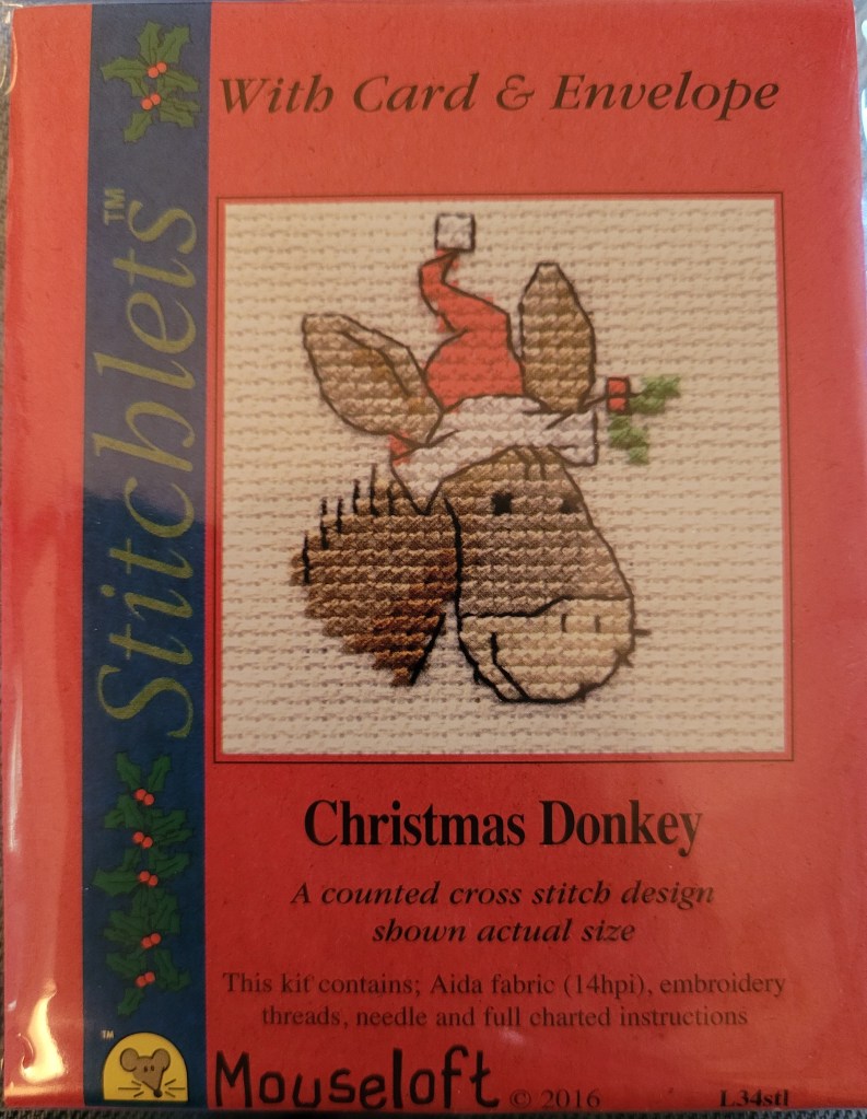 Package with cross stitched donkey with Santa hat.